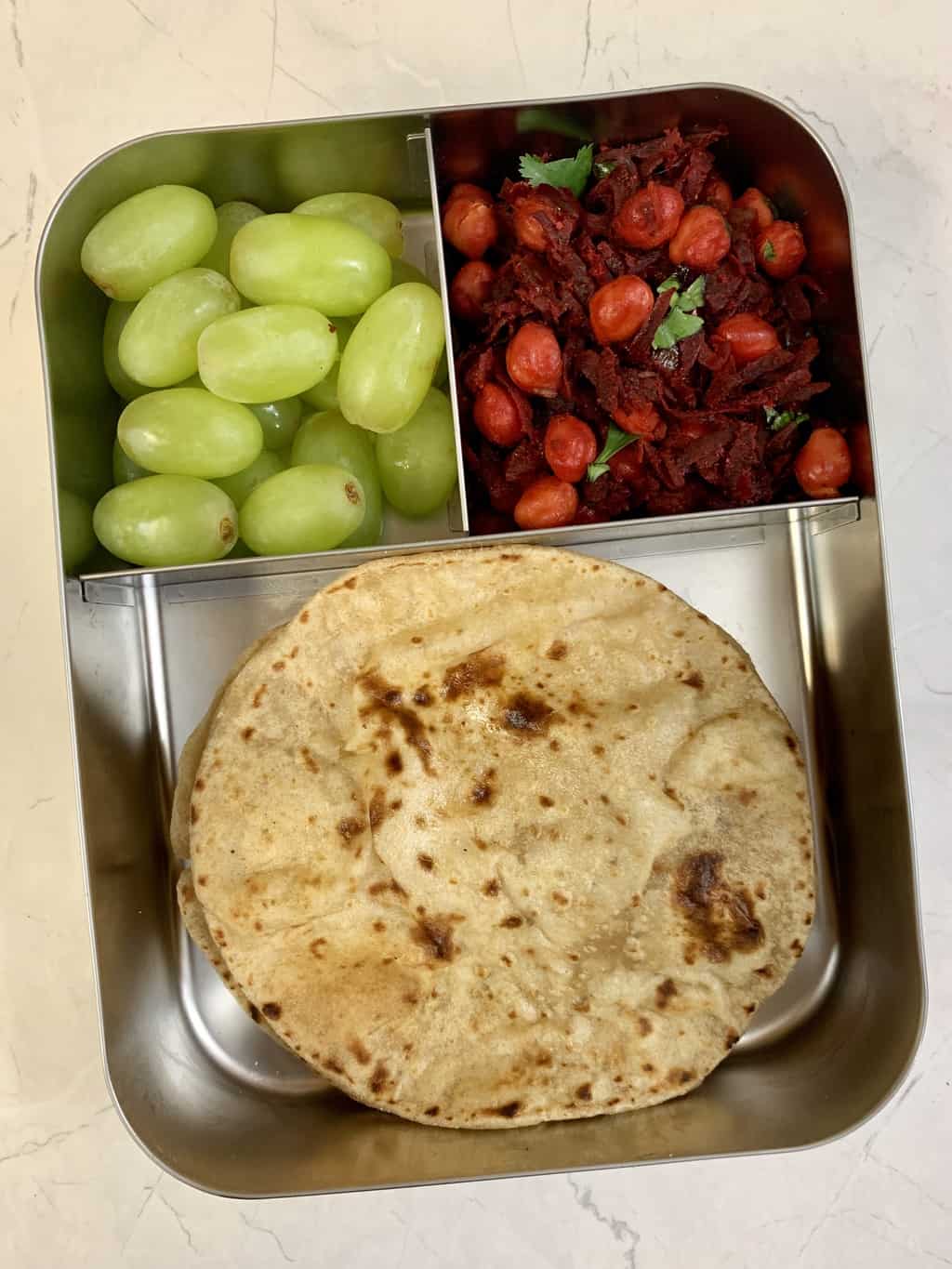 flax seed chapati with beetroot chickpeas stir fry and grapes in bento steel lunch box