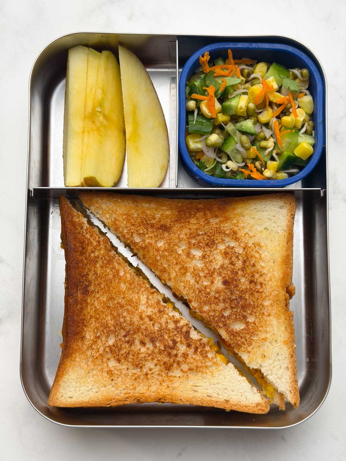 paneer bhurji sandwich with sprouted moong salad and apple slices in bento kids steel box