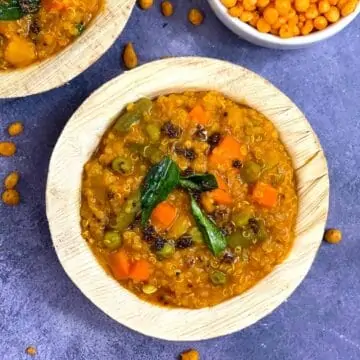 Quinoa Bisibelebath served in a bowl with boondi on the side