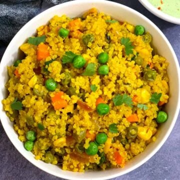 quinoa pulao served in a white bowl and raita on side