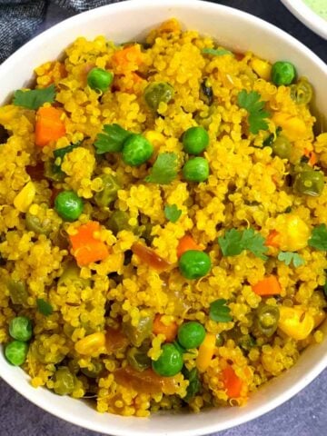 quinoa pulao served in a white bowl and raita on side