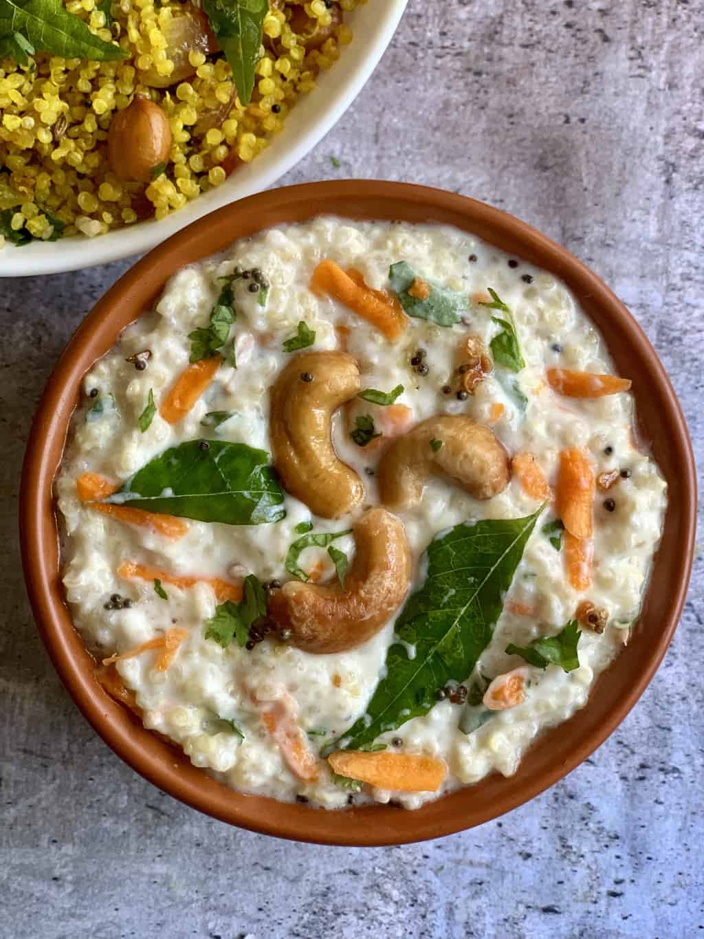 curd quinoa served in a bowl with roasted cashews on the top