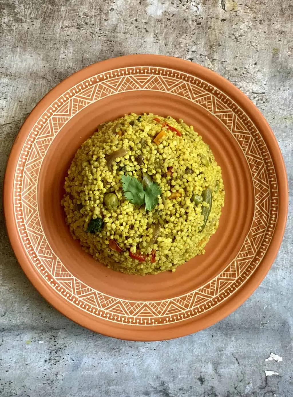 kodo millet pulao served on a plate garnished with cilantro
