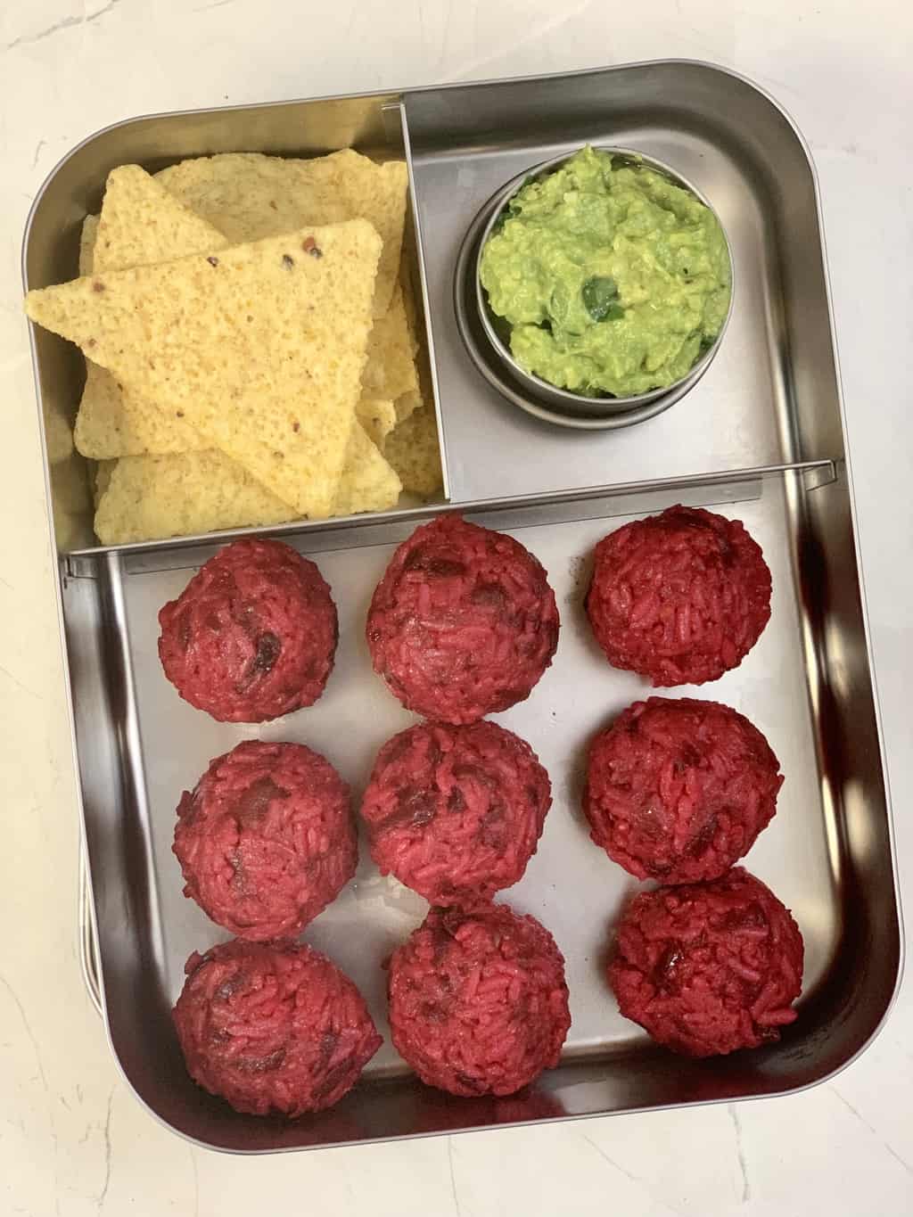 Beetroot Rice Ball with guacamole and tortilla chips in bento steel box.