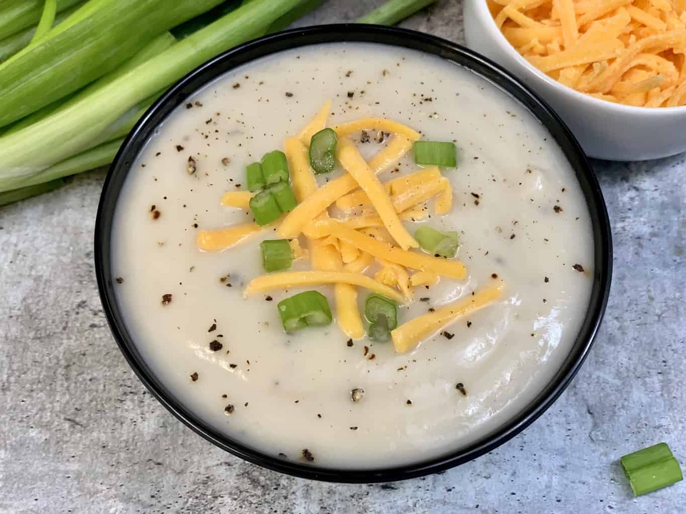 cauliflower soup in a black bowl