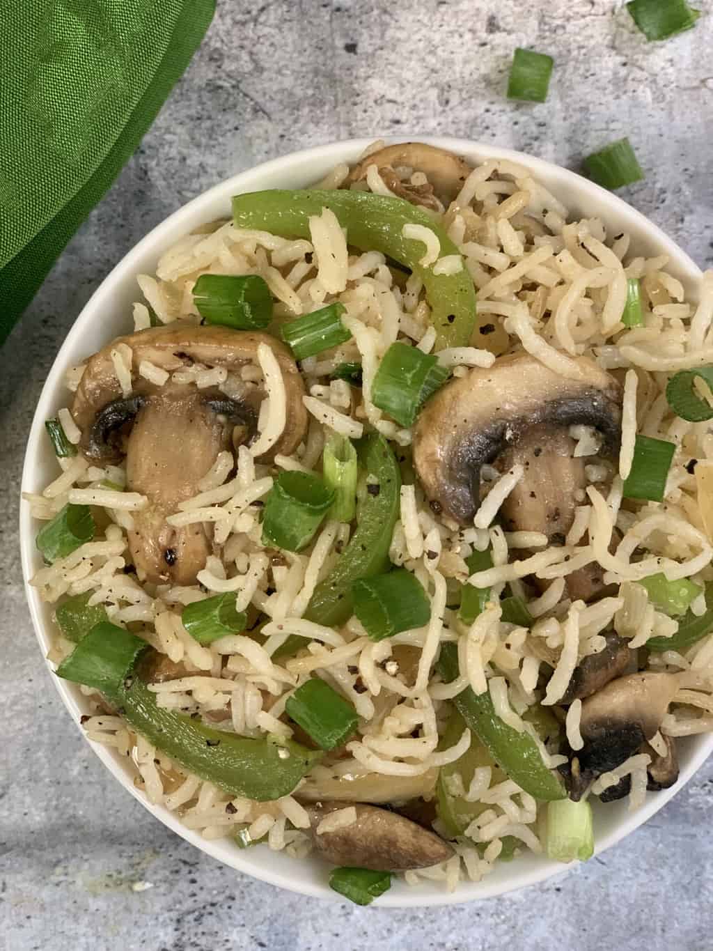 mushroom fried rice served in a bowl garnished with green onions