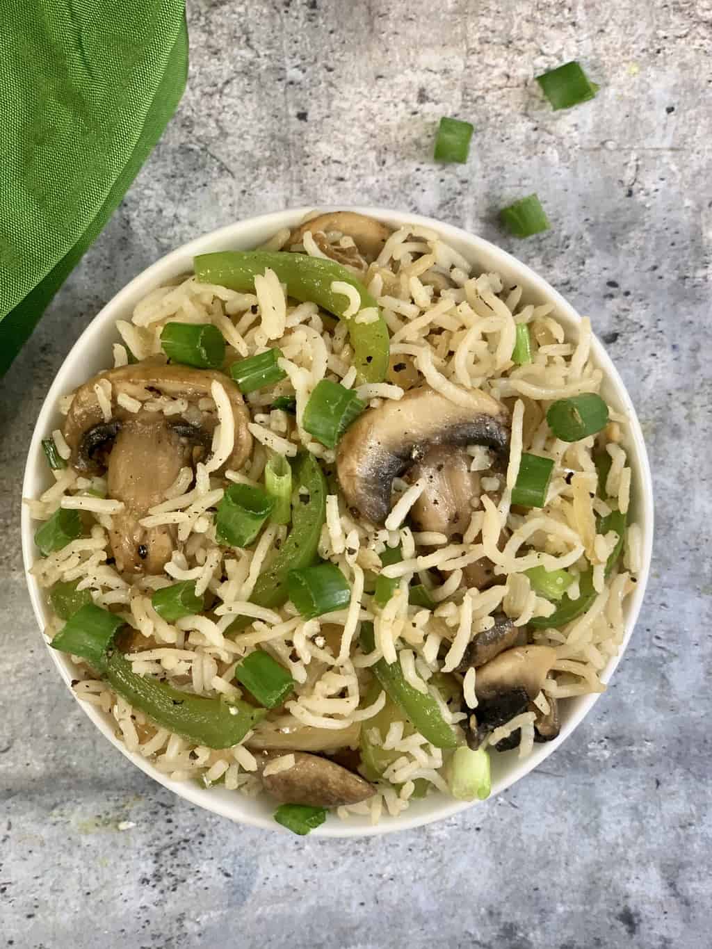 mushroom fried rice served in a bowl garnished with spring onions