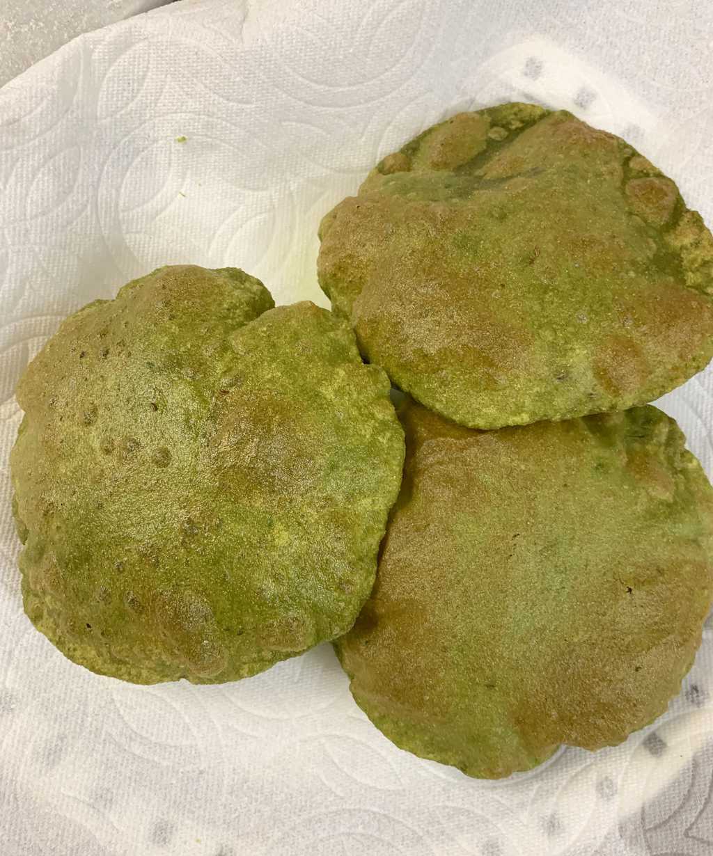 three palak poori on a plate