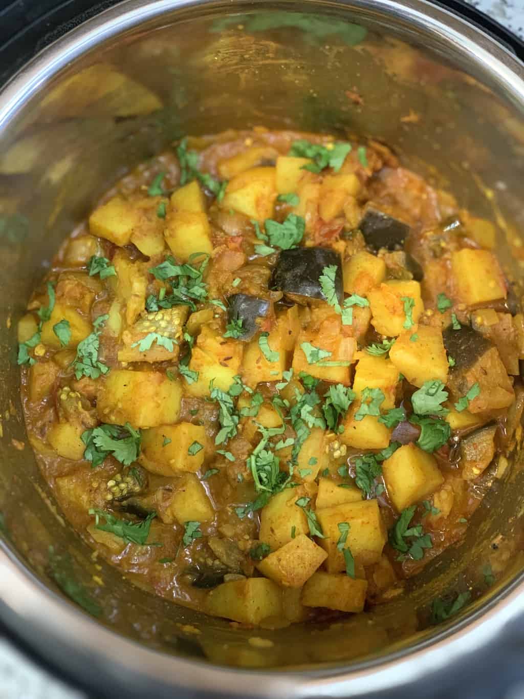 potato eggplant curry (aloo baingan) in instant pot insert garnished with cilantro