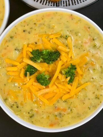 Instant Pot Broccoli Cheddar Cheese Soup served in a bowl garnished with cheddar soup and broccoli