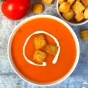 Instant Pot Creamy Tomato Soup served in a bowl with bread croutons and cream on top