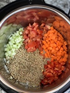 step to add veggies like celery tomatoes carrot bell pepper and green lentils