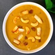 Moong dal Payasam served in a bowl garnished with fried coconut and nuts