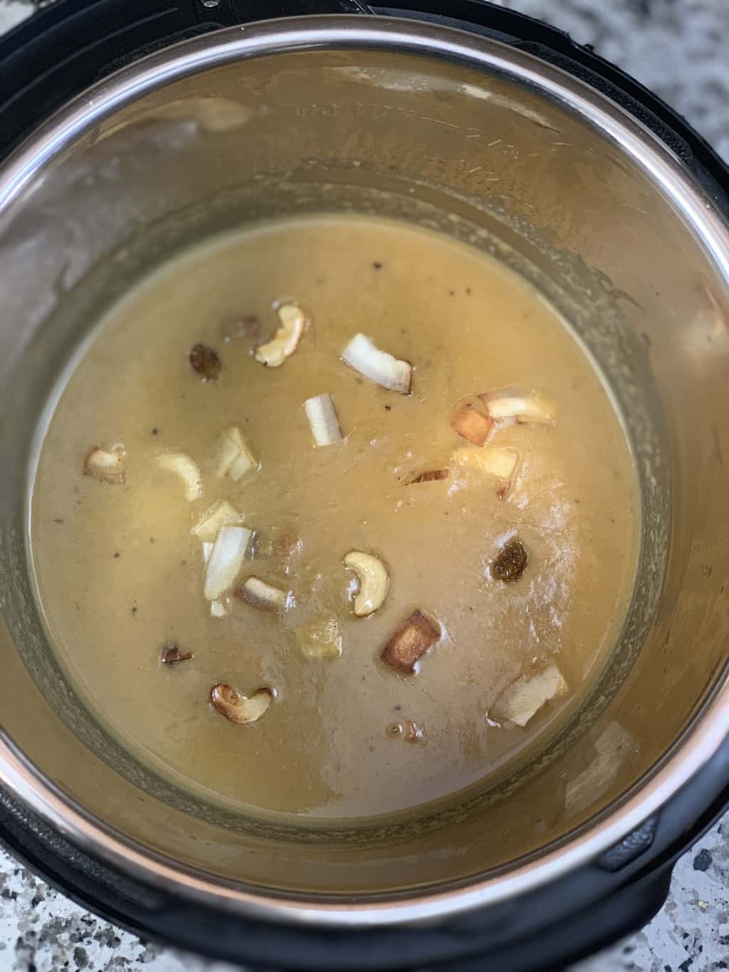 moong dal payasam in instant pot insert garnished with roasted nuts and coconut