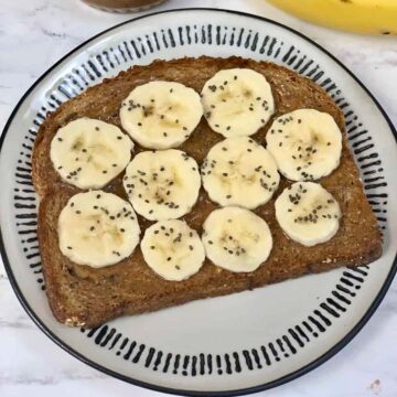 almond butter chia toast served on a plate with sliced banana and chia seeds on the top