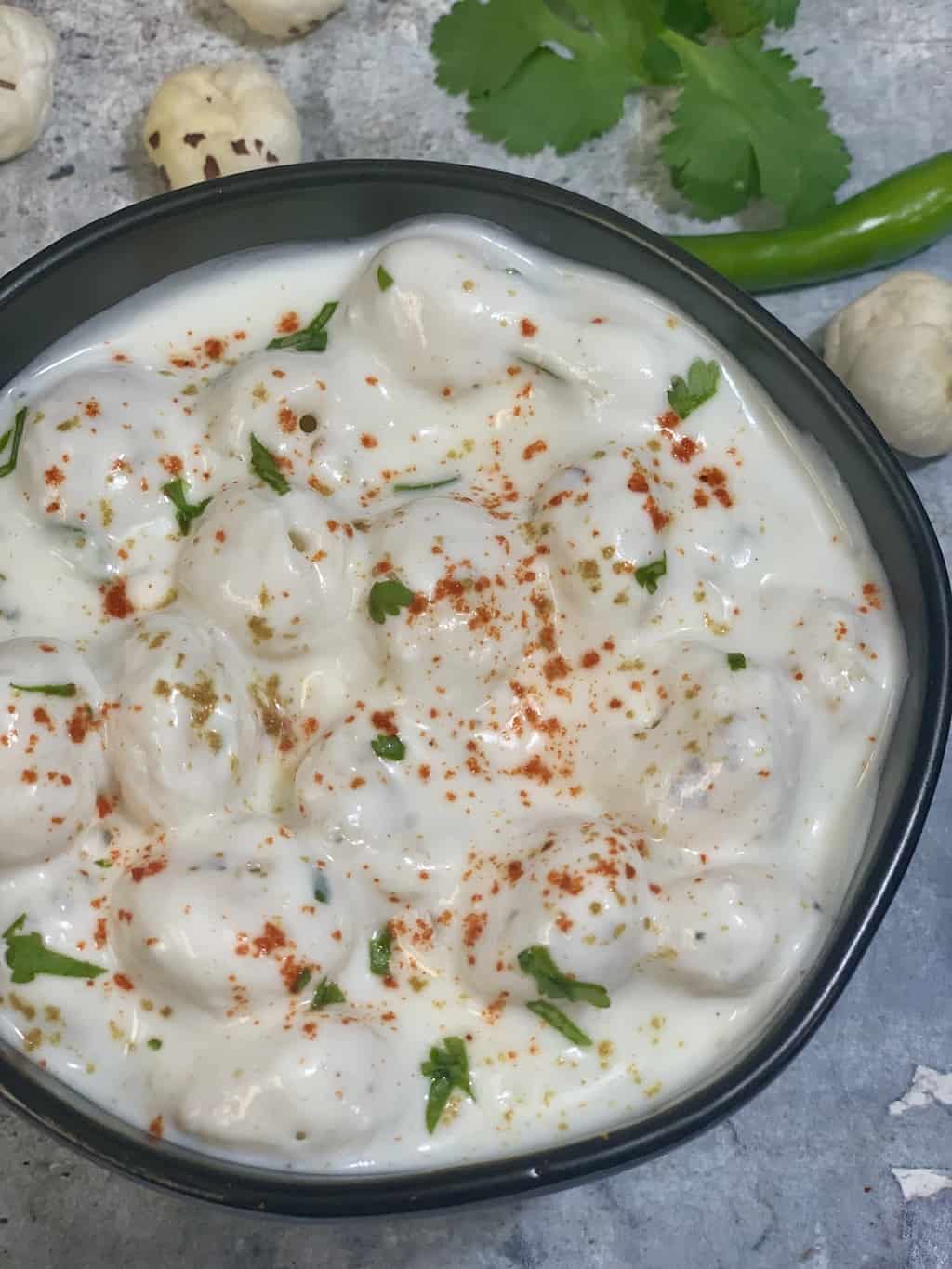 makhana raita served in a bowl garnished with cilantro