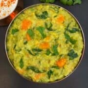 bajra khichdi served in a bowl with raita on the side