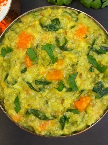 bajra khichdi served in a bowl with raita on the side