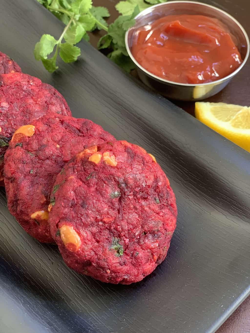 beetroot cutlet served on a tray with ketchup on the side