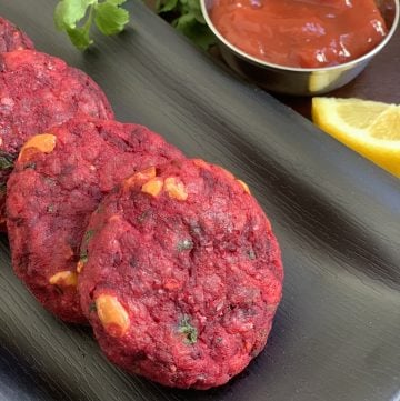 beetroot tikki layed on a plate with ketchup on the side
