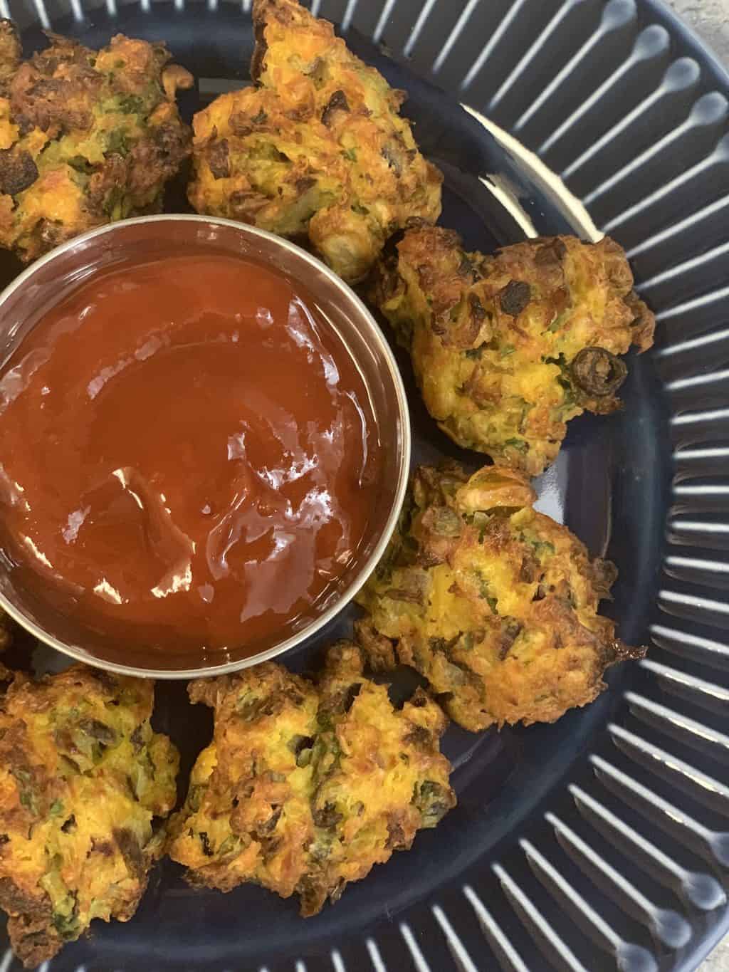 airfryer corn pakora served on a plate with tomato ketchup