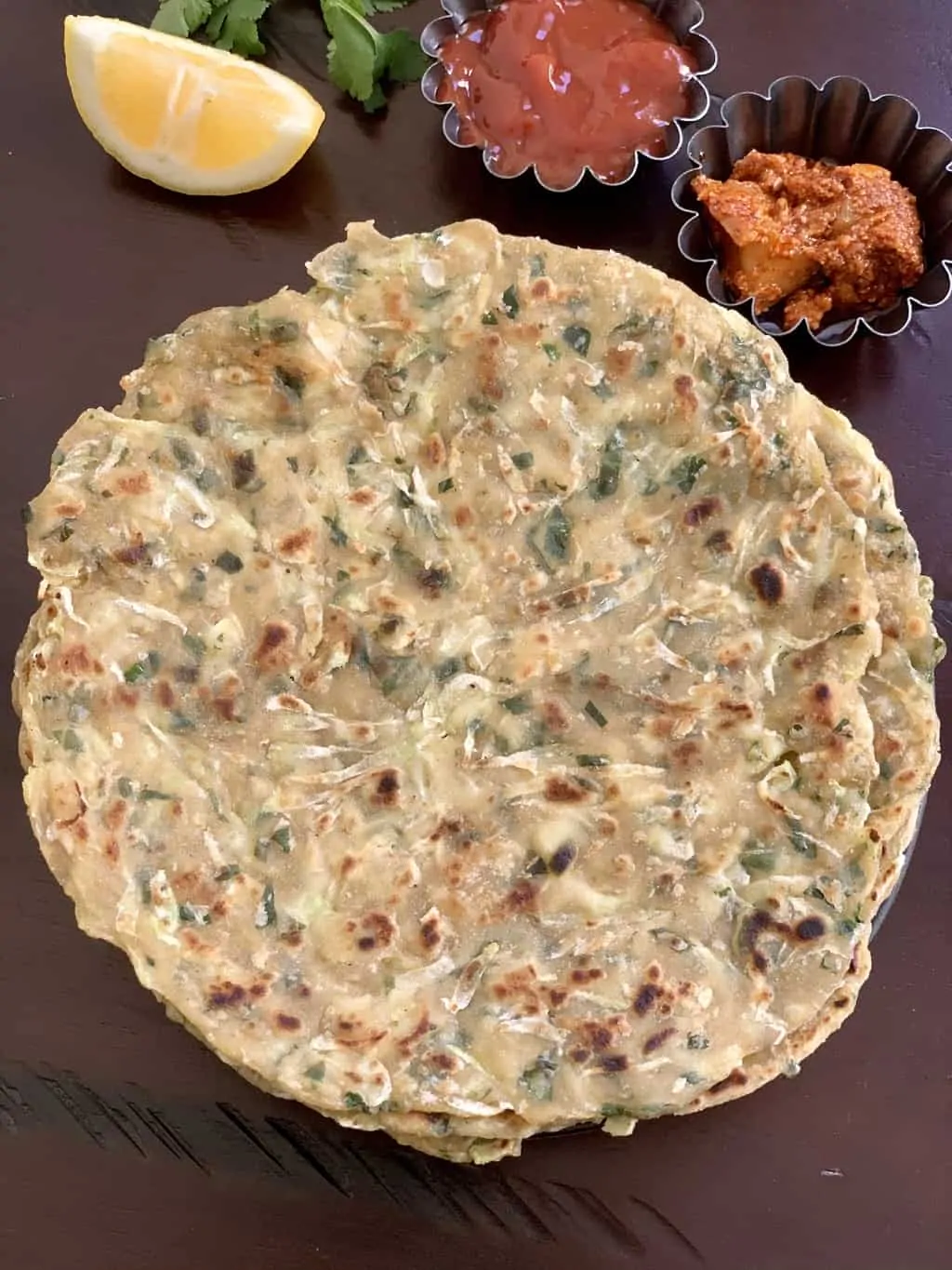 Lauki Paratha servi dans une assiette avec du cornichon en quartiers de citron sur le côté