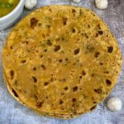 phool makhana paratha served on a plate with curry on the side