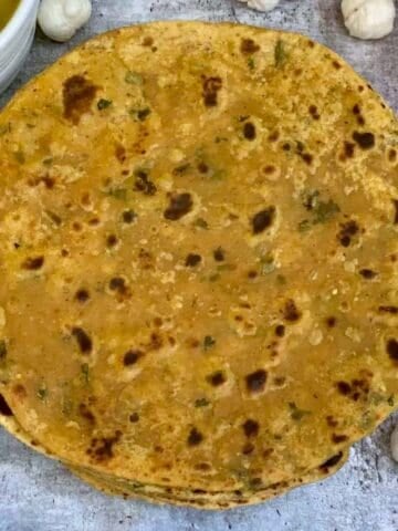 phool makhana paratha served on a plate with curry on the side