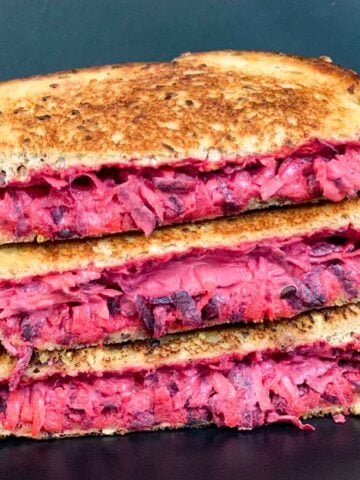 a stack of grilled beetroot carrot sandwich on a plate