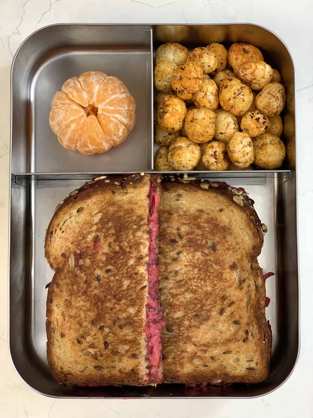 Beetroot Carrot Sandwich, Peri Peri Makhana and Orange in bento steel lunch box.