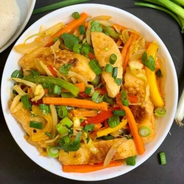 Vegetable Fried Idli served in a bow garnished with green onions