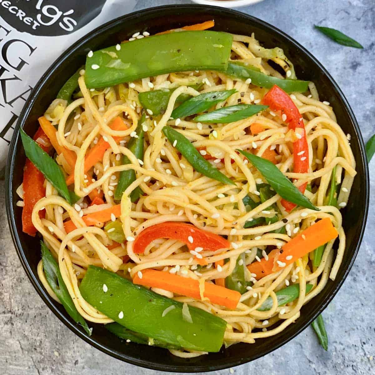Instant Pot Vegetable Hakka Noodles served in a bowl garnished with green onions and sesame seeds