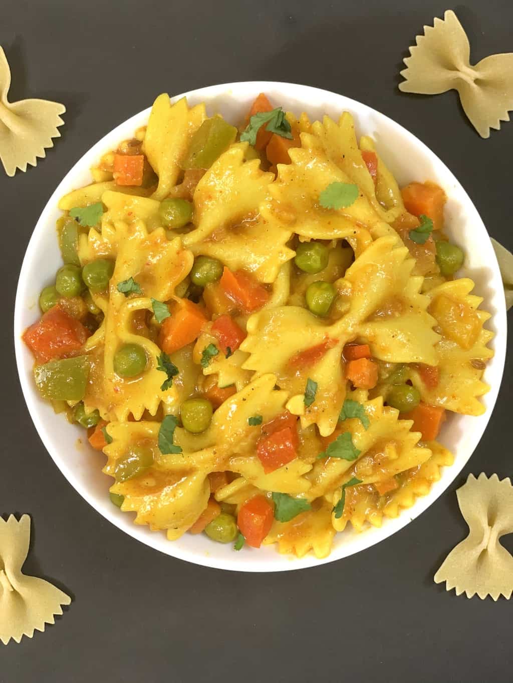 Indian style masala pasta served in a bowl garnished with cilantro
