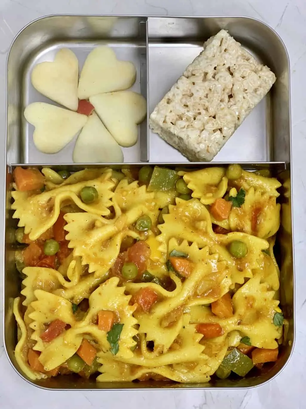 Masala Pasta in kids lunch box with Rice Krispies and Apple