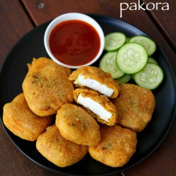 paneer pakora served with ketchup and cucumber slices on a plate