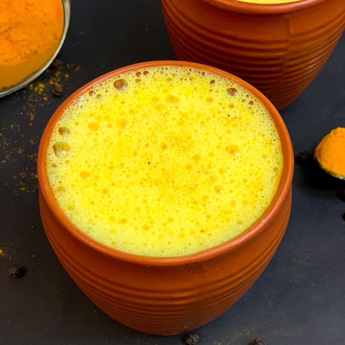 Turmeric golden milk (haldi doodh) served in a mud serving glass