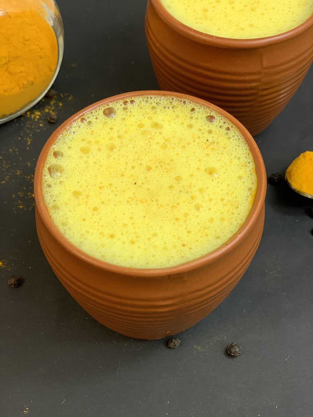 turmeric latte beverage  served in mud serving glass