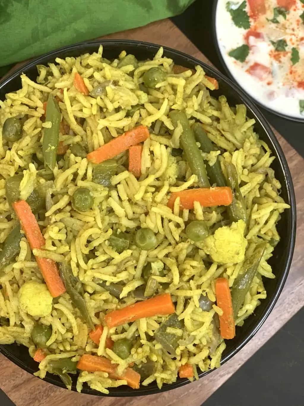 veg pulao tálalva egy tál raita oldalán