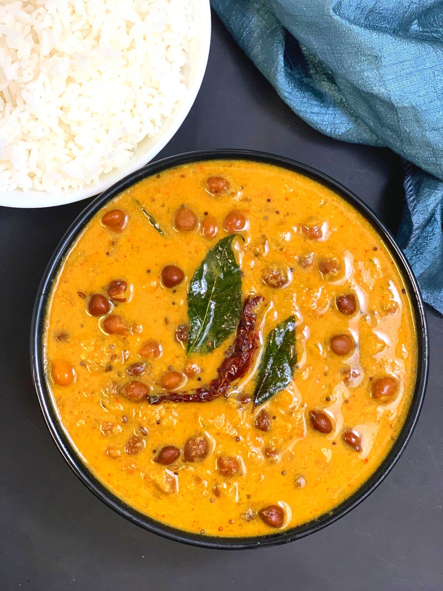 instant pot kerala kadala curry served in a black bowl served with white rice on side