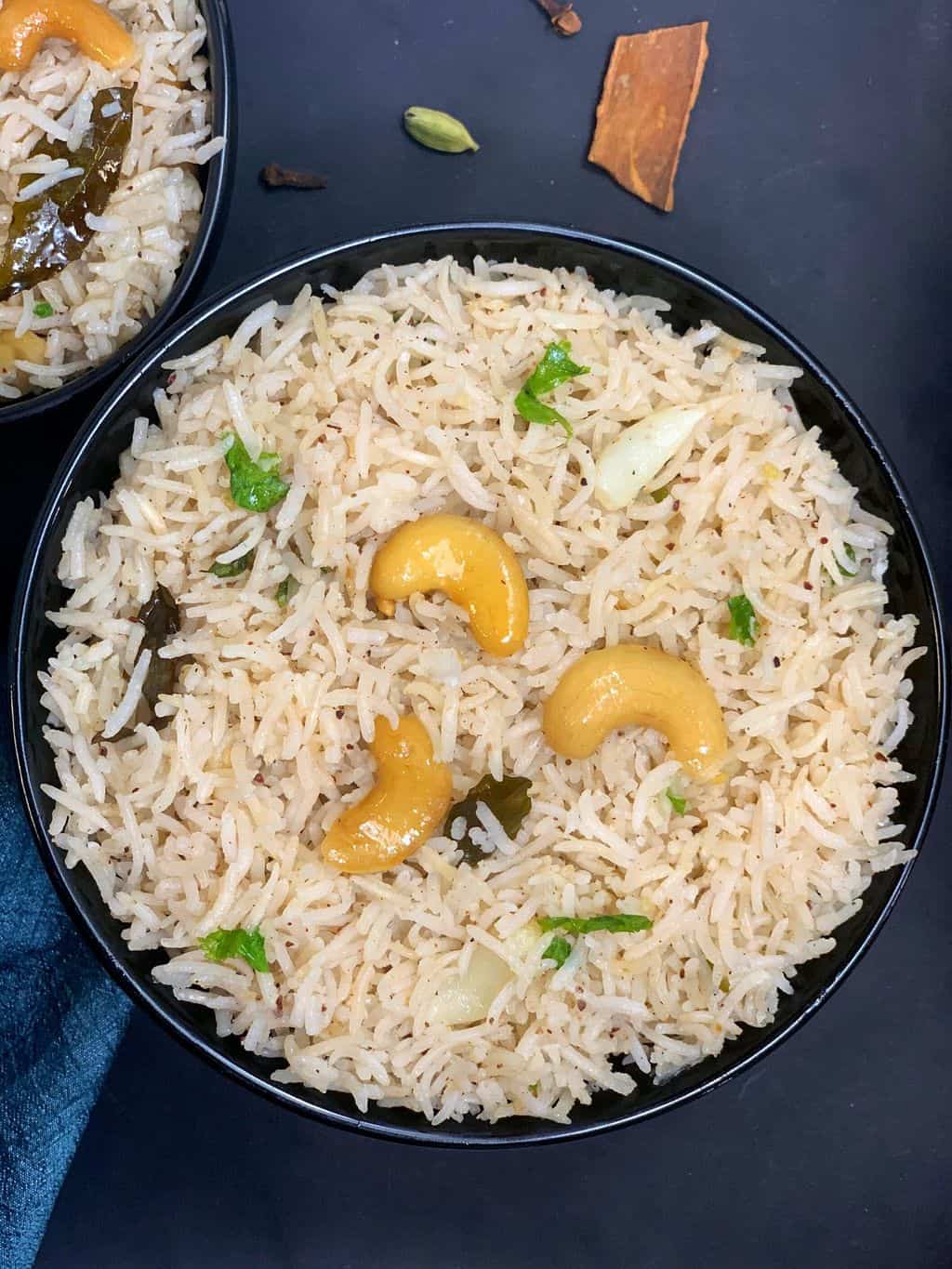 biranji anna served in a bowl topped with roasted cashews and cilantro