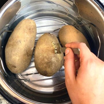 instant pot boiled potato in the instant pot insert with fork inserted to check the doneness