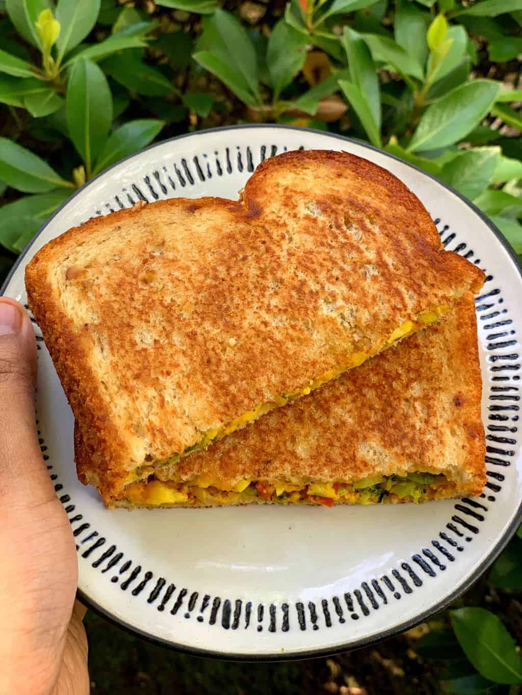 broccoli sandwich cut into half served on a plate