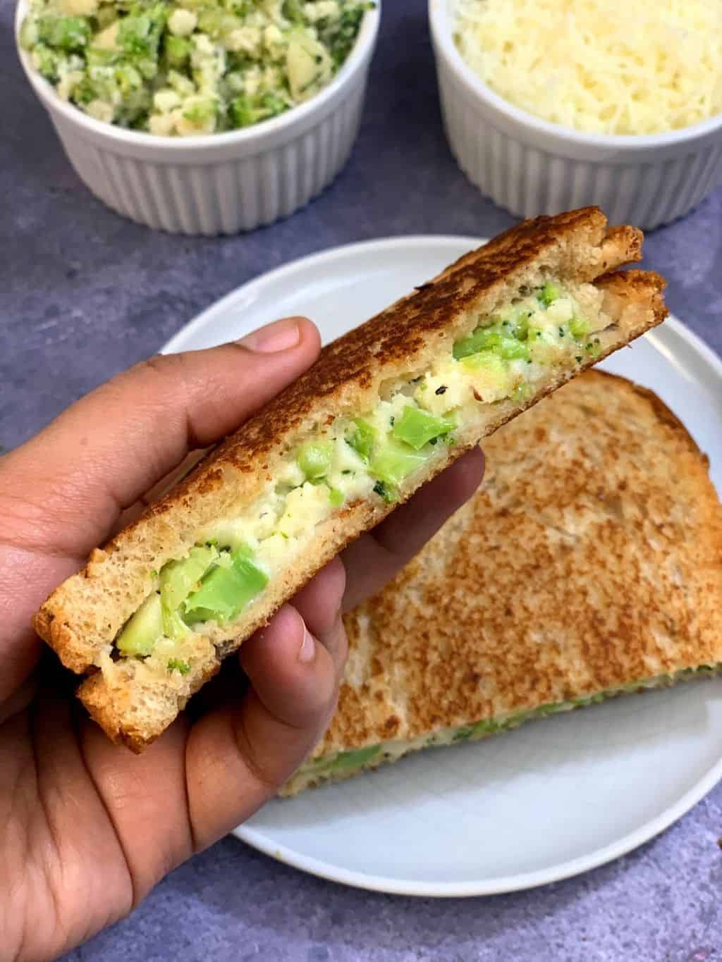 holding Broccoli mayo sandwich in left hand 