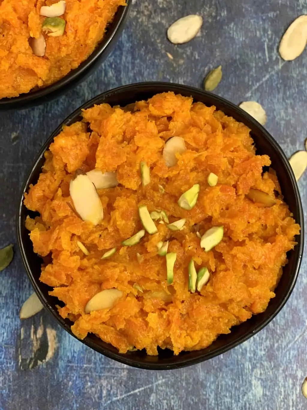 instant pot carrot halwa served in a bowl garnished with nuts