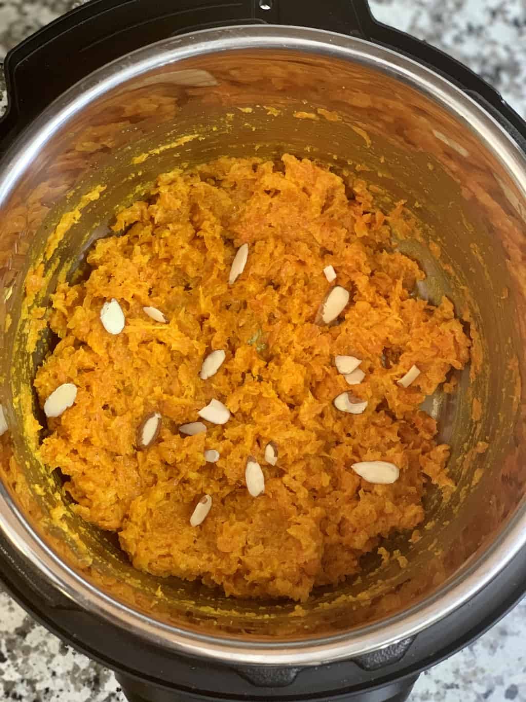carrot halwa in instant pot insert garnished with nuts