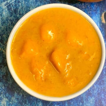 mango rasayana in a bowl with mango on the side