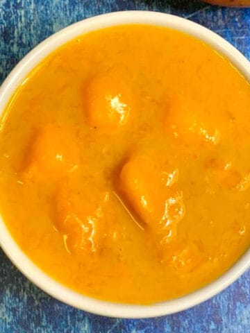 mango rasayana in a bowl with mango on the side