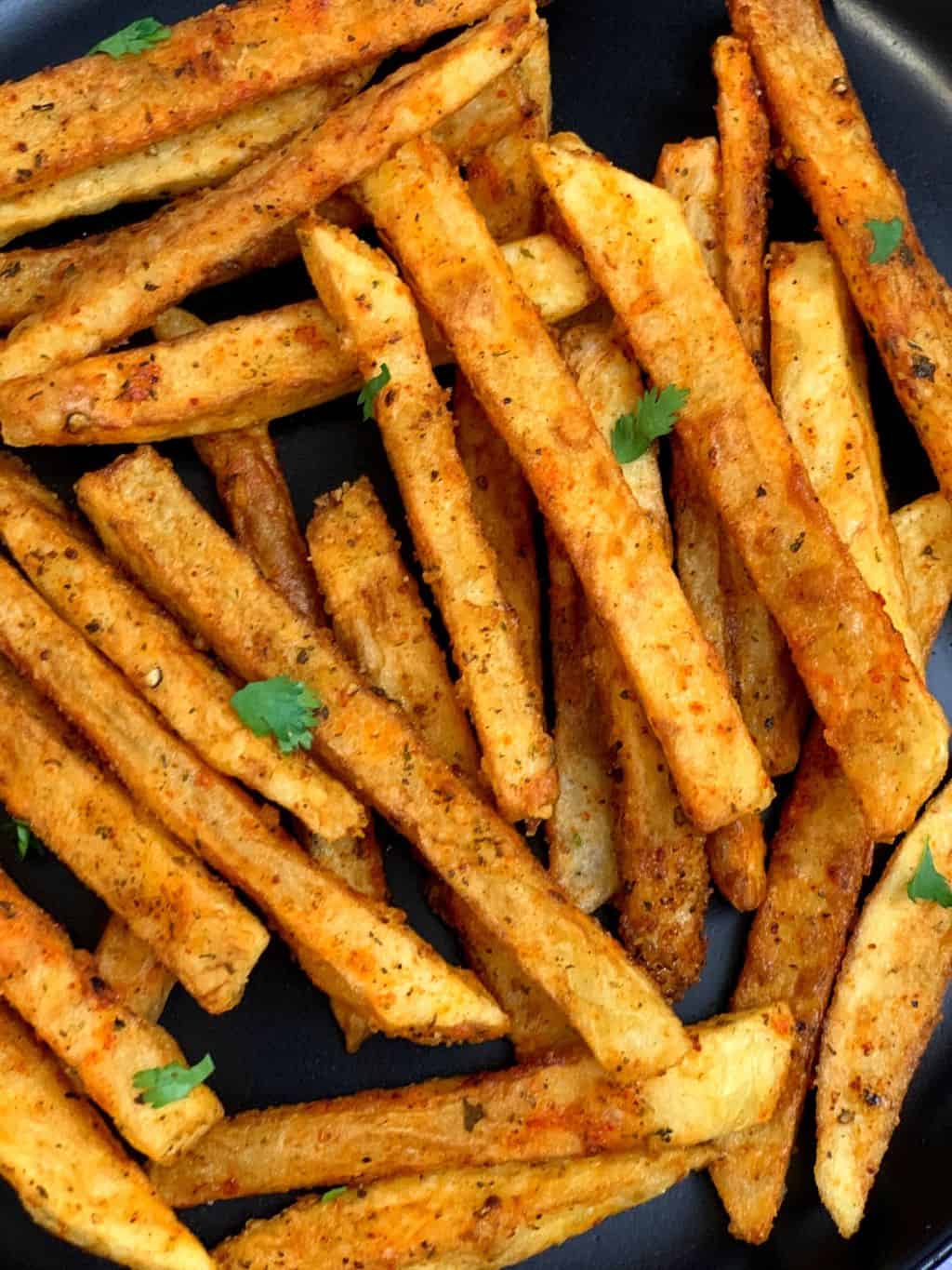 masala french fries served in a plate garnished with cilantro