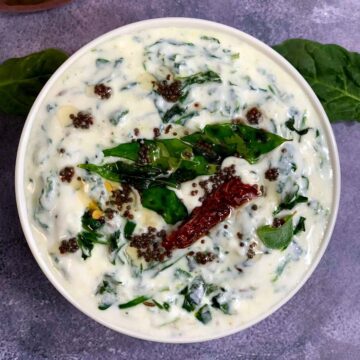 spinach raita served in a bowl with tempering on the top