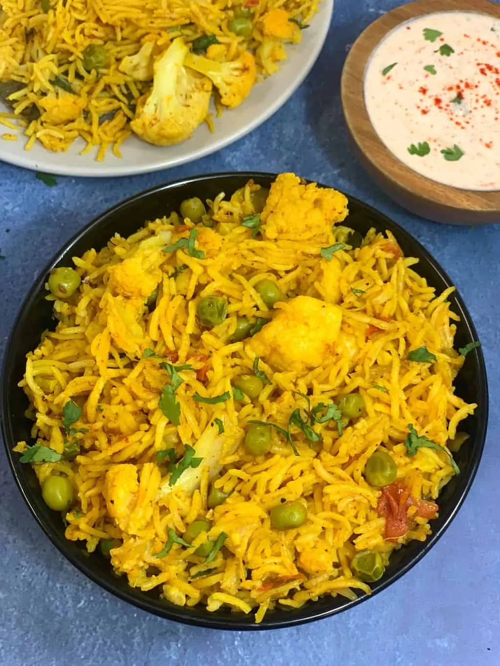 cauliflower Pulao recipe served in a bowl with raita on the side
